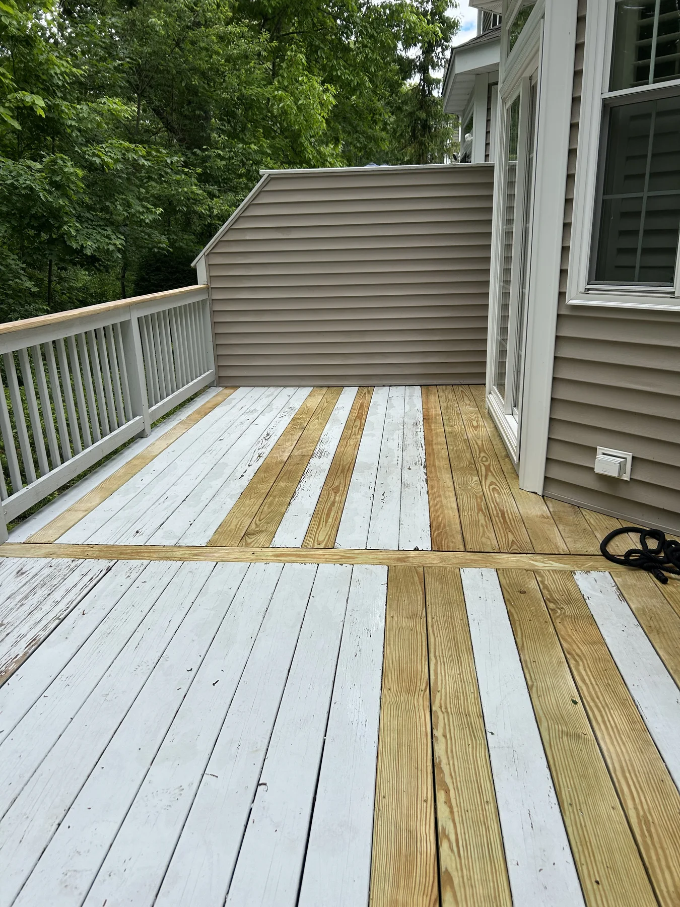 After: the same deck washed clean, with fresh wood showing between white boards