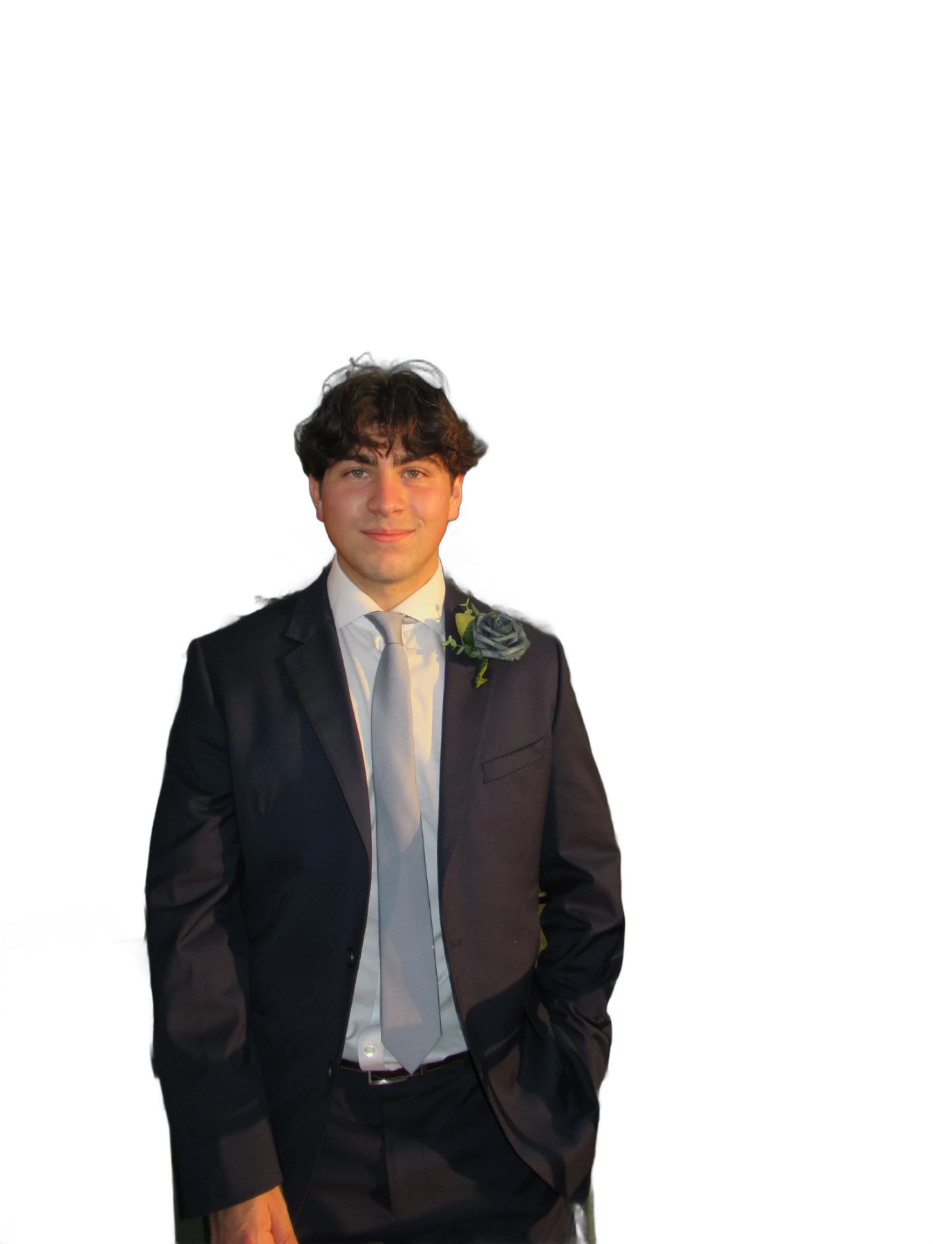 Evan Melendez in a navy suit and gray tie, standing on a balcony above a golf course at sunset