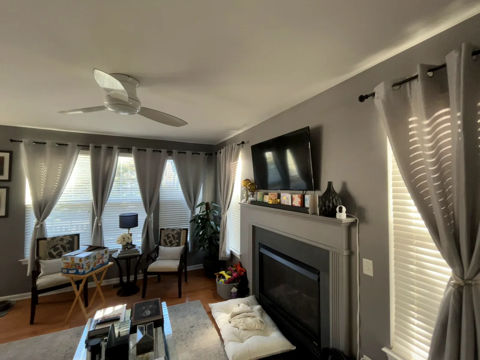 Finished living room with deep gray walls, gray curtains and a fireplace