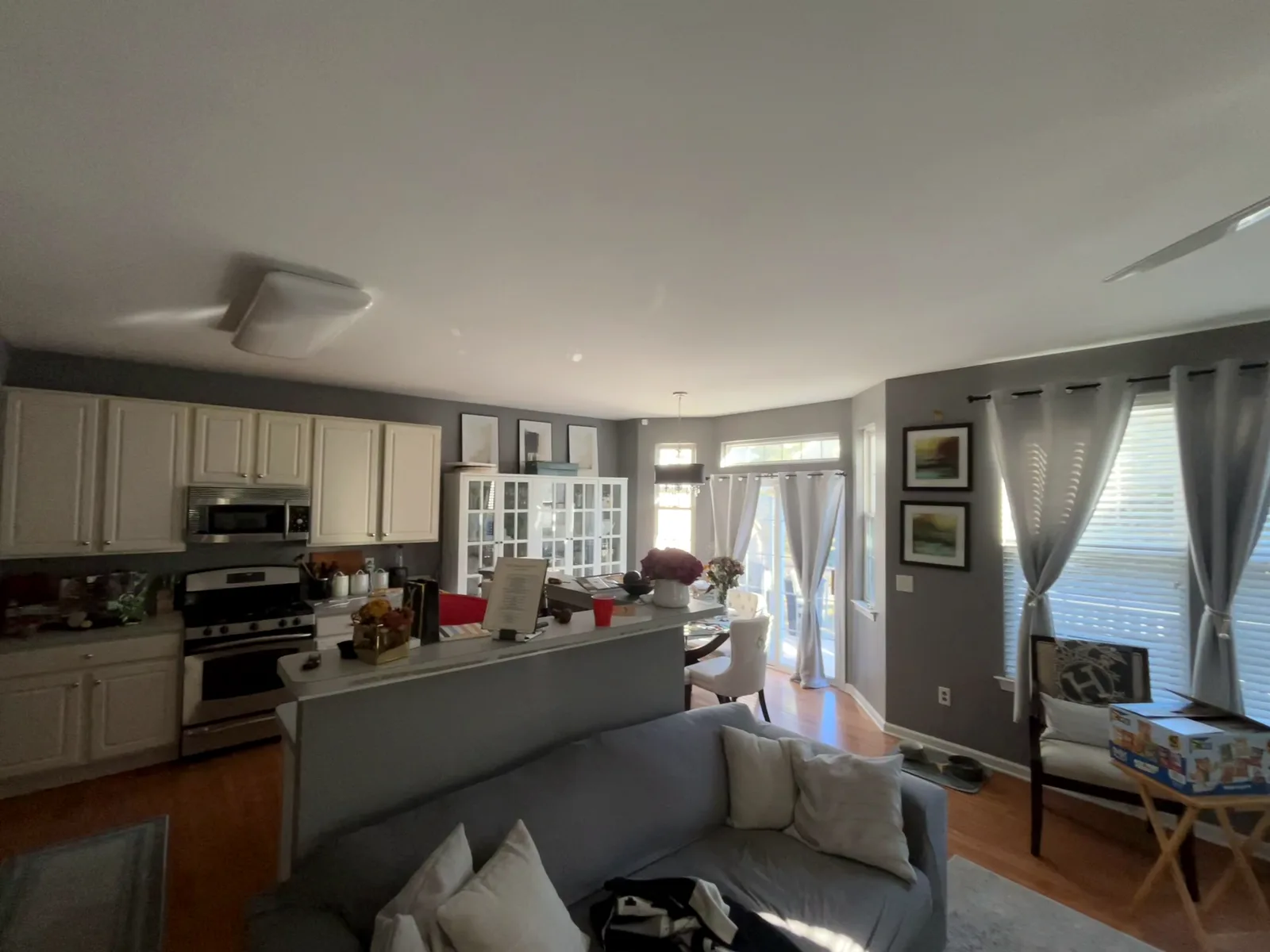 Open kitchen and living area with white cabinets and gray walls