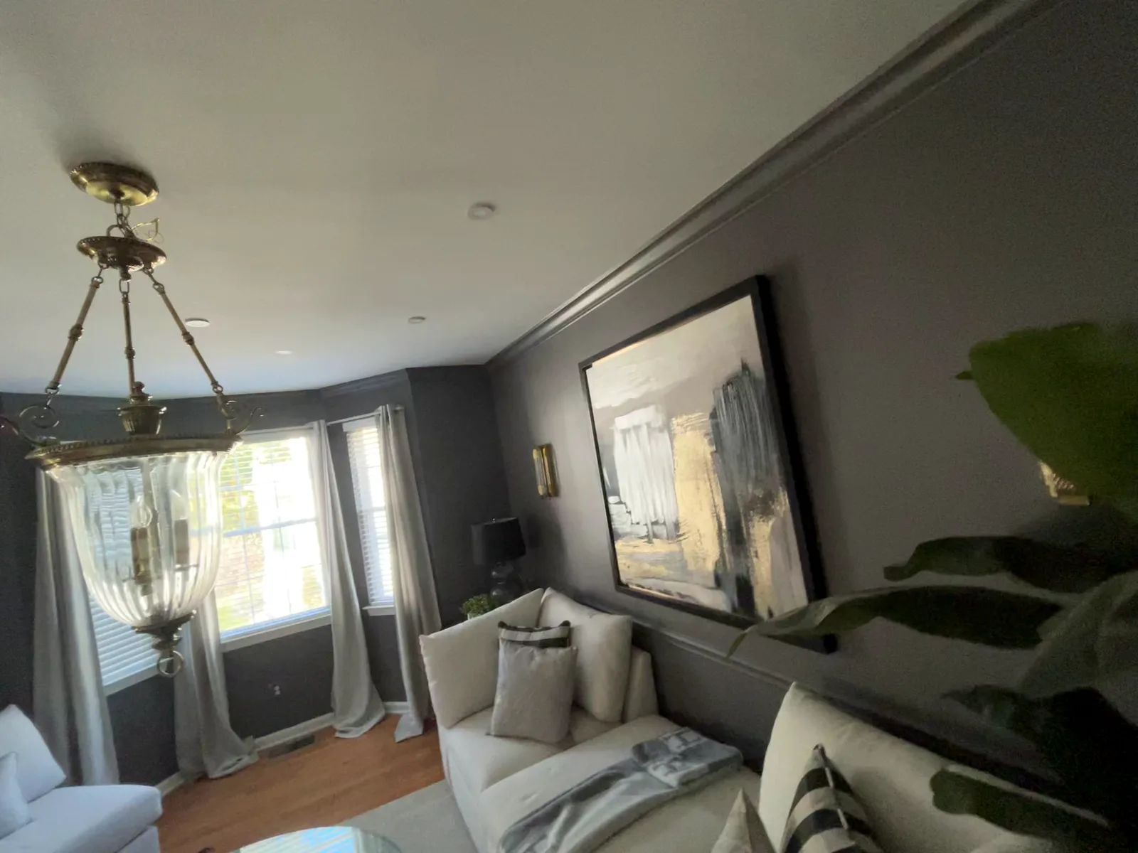 Sitting room under a glass chandelier, dark gray walls with crown molding